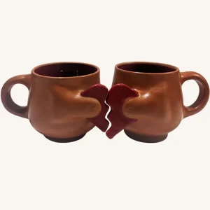 Dos tazas de barro con patitas de gato sosteniendo un corazón