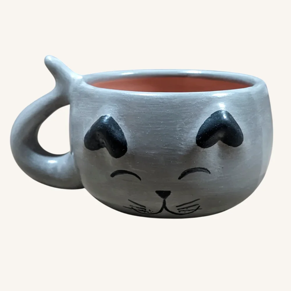 Taza-de-gato-artesanal-gris-frente Una taza de gato en color gris con carita feliz pintada a mano