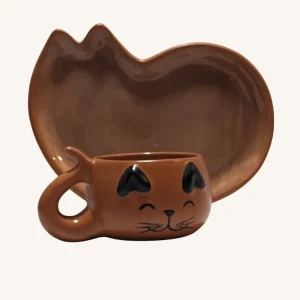Juego artesanal de taza y plato con forma de gato, hechos a mano en barro rojo con acabado natural.