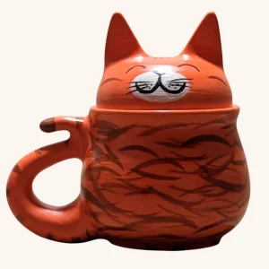 Taza de gato naranja artesanal hecha en barro rojo de Oaxaca, con detalles en rayas café y tapa con orejitas y carita feliz pintada.
